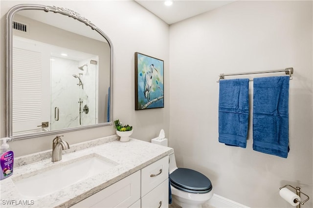 bathroom with vanity, toilet, and a shower with door