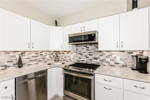 kitchen featuring backsplash, white cabinetry, and appliances with stainless steel finishes