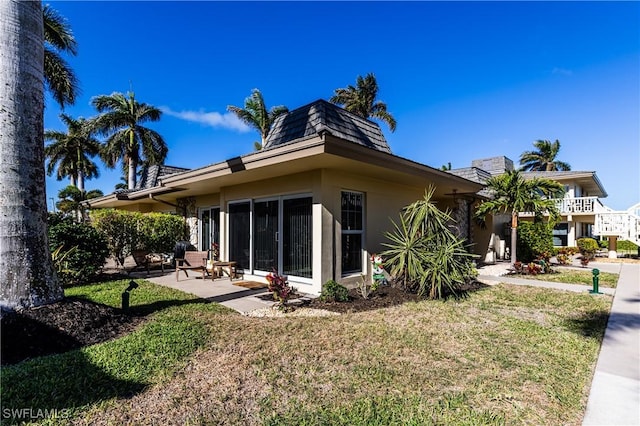 rear view of property with a yard and a patio