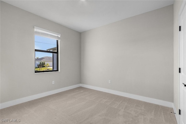 carpeted spare room with baseboards