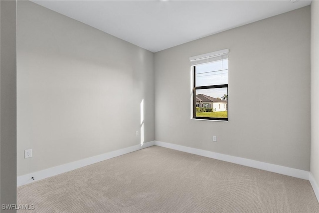 carpeted spare room featuring baseboards