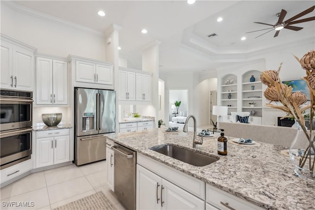 kitchen with white cabinets, sink, ornamental molding, appliances with stainless steel finishes, and light tile patterned flooring