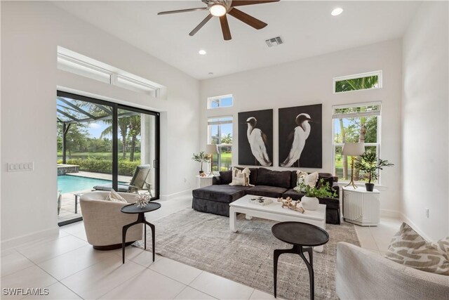 living room featuring ceiling fan, plenty of natural light, and light tile patterned floors