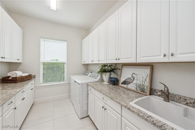 laundry area with light tile patterned flooring, cabinets, sink, and washing machine and dryer