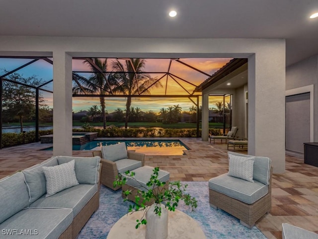 patio terrace at dusk featuring glass enclosure, an outdoor living space, and an in ground hot tub