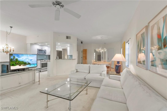 living room featuring light colored carpet and ceiling fan with notable chandelier