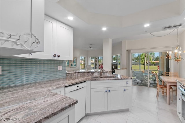 kitchen featuring white dishwasher, stone countertops, white cabinetry, and sink