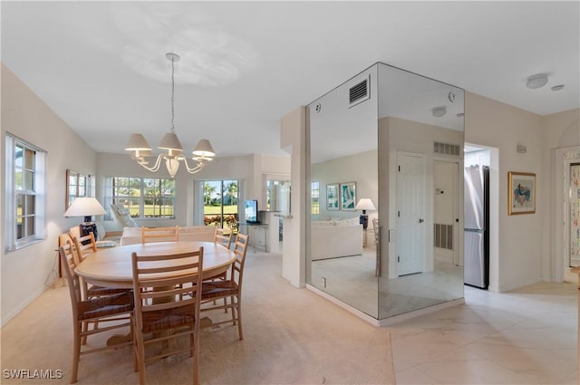 carpeted dining area featuring a chandelier