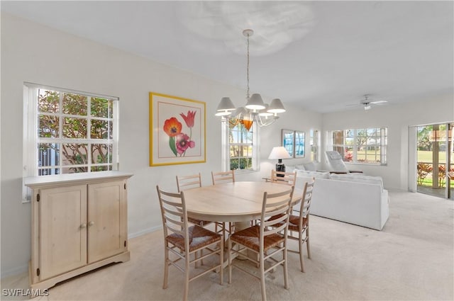 dining area featuring ceiling fan with notable chandelier and light colored carpet