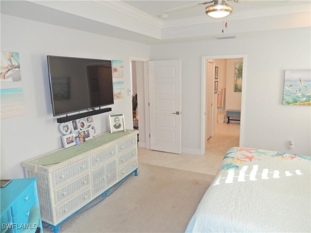 carpeted bedroom with a raised ceiling, ceiling fan, and ornamental molding