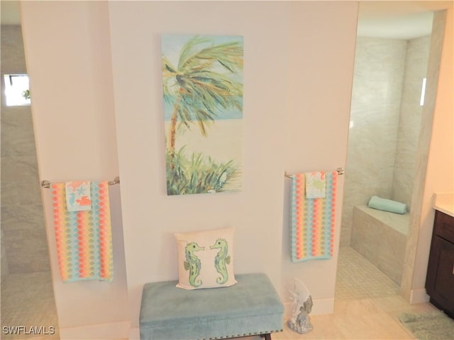 bathroom with tiled shower and vanity