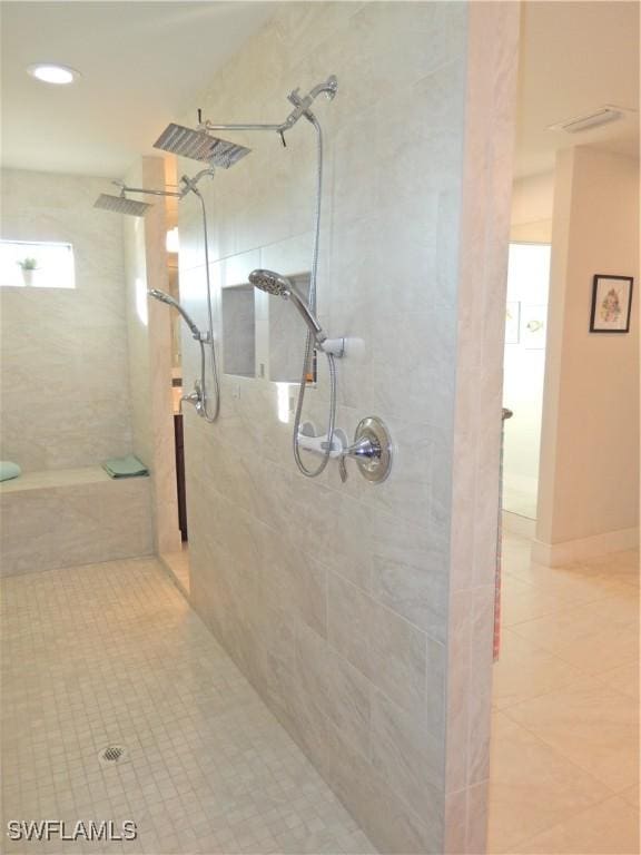 bathroom featuring tile patterned flooring and tiled shower