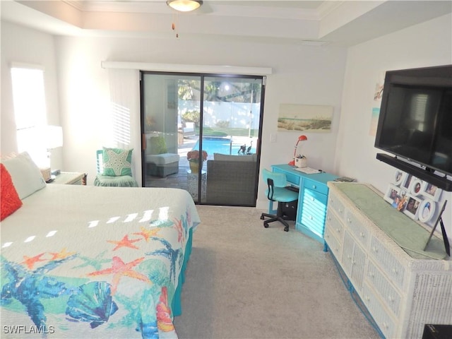 bedroom with a raised ceiling, access to exterior, and light colored carpet