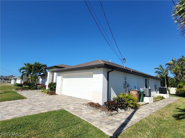 view of home's exterior featuring cooling unit, a garage, and a yard