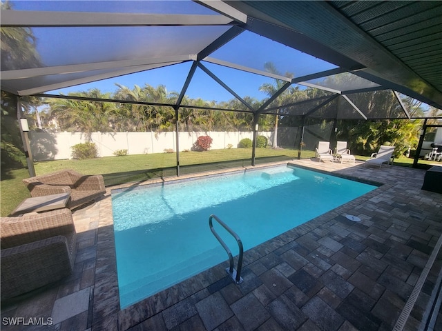 view of swimming pool featuring a patio area, a yard, and glass enclosure