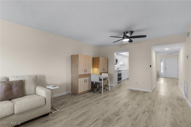 living room featuring ceiling fan and light wood-type flooring