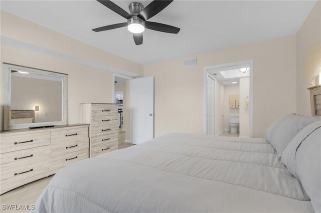 bedroom with ensuite bathroom, ceiling fan, and light wood-type flooring