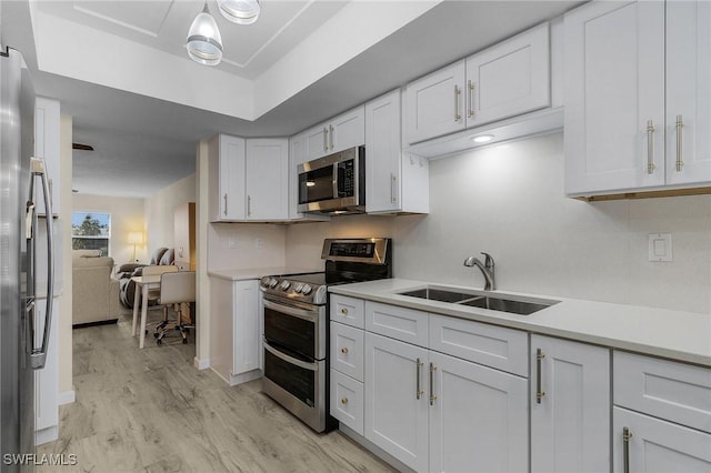 kitchen featuring sink, stainless steel appliances, and white cabinets