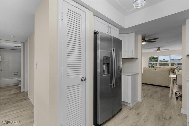 kitchen featuring white cabinetry, stainless steel refrigerator with ice dispenser, ceiling fan, and light wood-type flooring