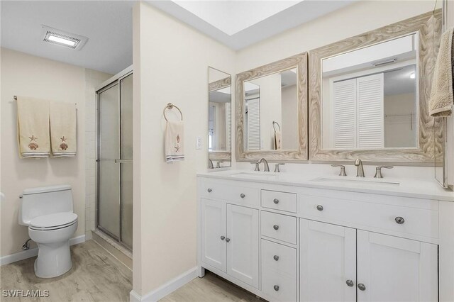 bathroom featuring hardwood / wood-style flooring, vanity, toilet, and an enclosed shower