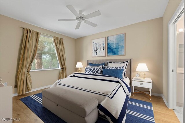 bedroom with ceiling fan, ensuite bathroom, and light wood-type flooring