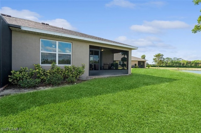 rear view of property with a lawn and a sunroom