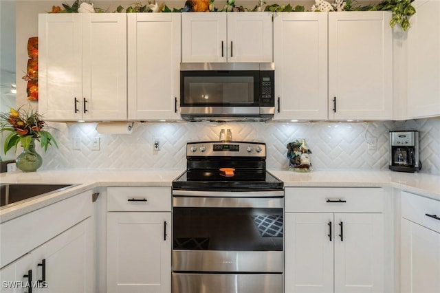 kitchen featuring white cabinets, stainless steel appliances, and tasteful backsplash