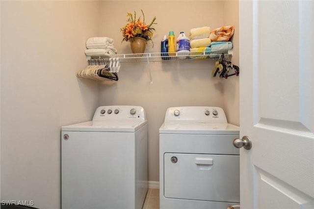 clothes washing area featuring separate washer and dryer and tile patterned flooring