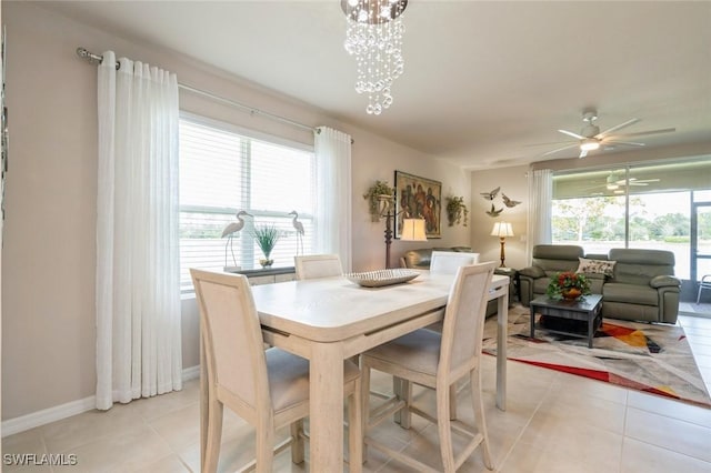 tiled dining space with ceiling fan with notable chandelier