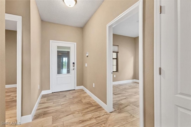 entrance foyer with a textured ceiling and light hardwood / wood-style flooring