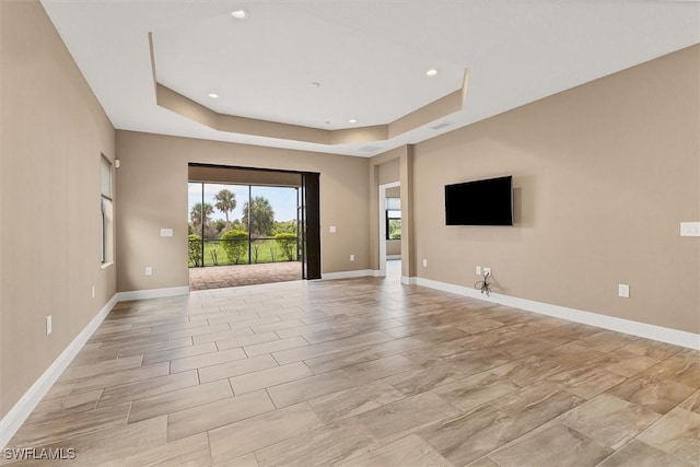 unfurnished living room featuring a raised ceiling