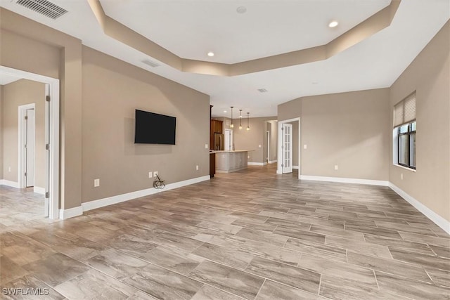 unfurnished living room with a tray ceiling