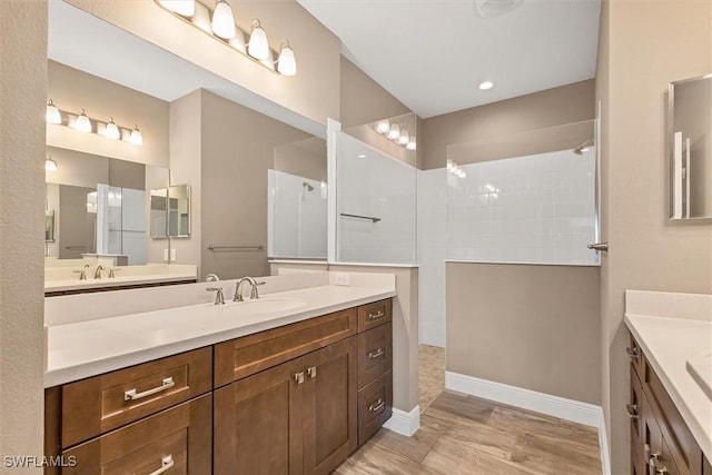 bathroom with hardwood / wood-style flooring, a shower, and vanity