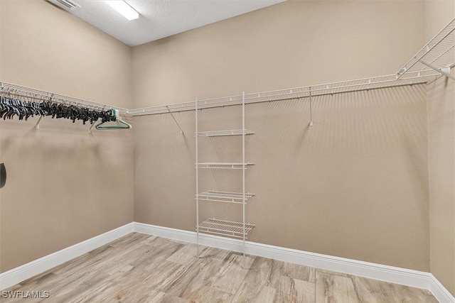 walk in closet with hardwood / wood-style flooring