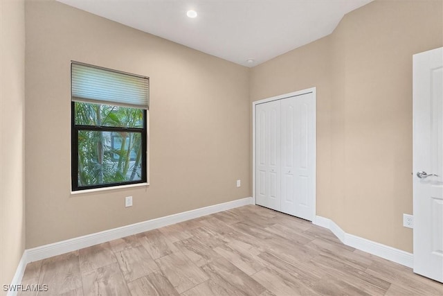 unfurnished bedroom with light hardwood / wood-style floors and a closet