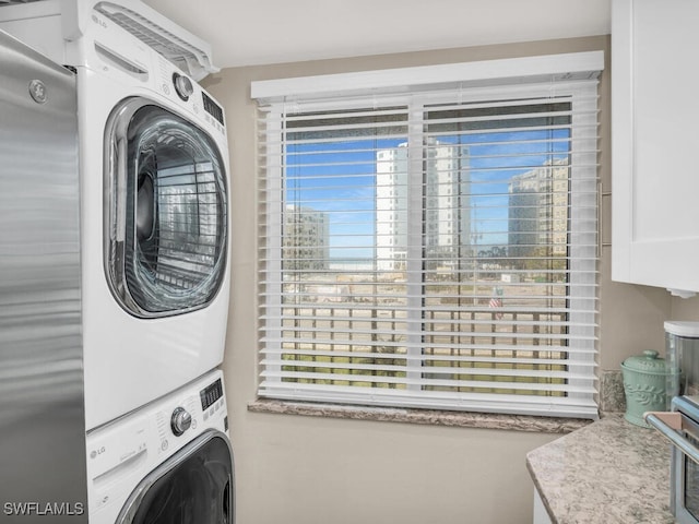 clothes washing area featuring stacked washer / drying machine