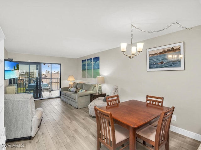 dining area featuring light hardwood / wood-style floors and an inviting chandelier