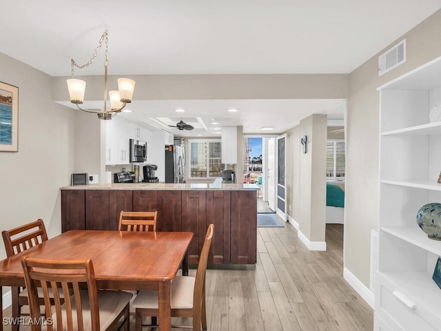 dining area with a notable chandelier and light hardwood / wood-style floors