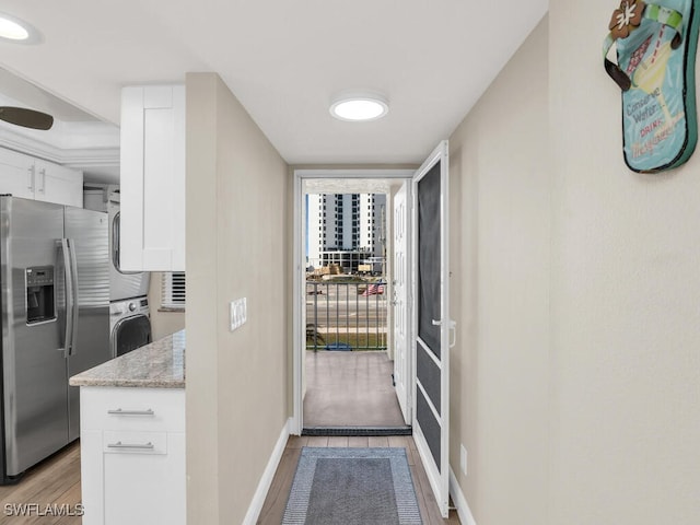 interior space featuring light wood-type flooring and stacked washer / dryer