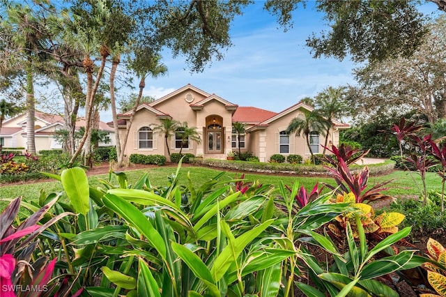 mediterranean / spanish-style house featuring a front yard