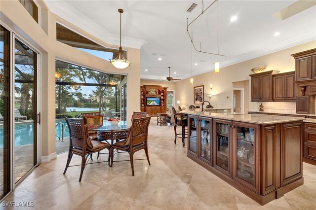 dining space with ceiling fan and crown molding