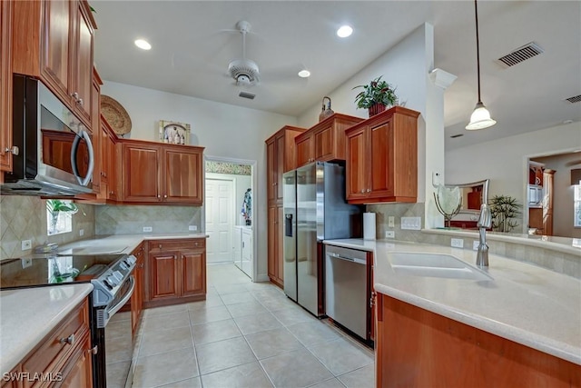 kitchen featuring sink, stainless steel appliances, pendant lighting, decorative backsplash, and light tile patterned flooring