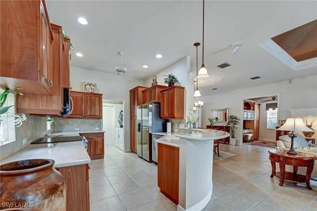 kitchen featuring kitchen peninsula, pendant lighting, stainless steel appliances, and ceiling fan