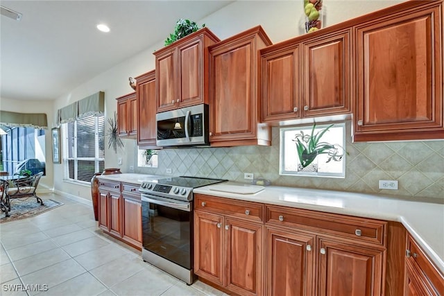 kitchen featuring light tile patterned floors, stainless steel appliances, and tasteful backsplash