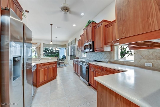 kitchen with hanging light fixtures, decorative backsplash, ceiling fan, light tile patterned floors, and appliances with stainless steel finishes