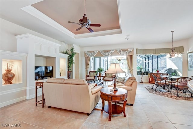 tiled living room featuring ceiling fan with notable chandelier and a raised ceiling