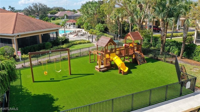 view of jungle gym with a yard and a community pool