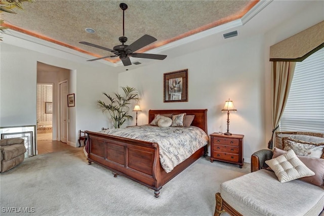 bedroom featuring a tray ceiling, connected bathroom, ceiling fan, and a textured ceiling