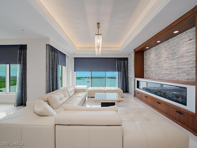 living room featuring a tray ceiling, an inviting chandelier, and plenty of natural light