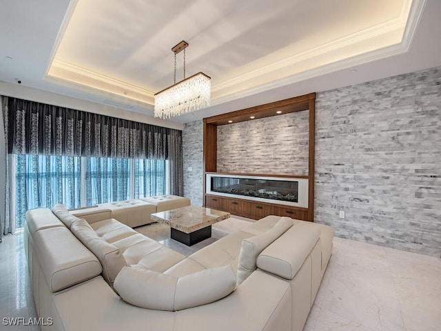 living room featuring an inviting chandelier and a tray ceiling